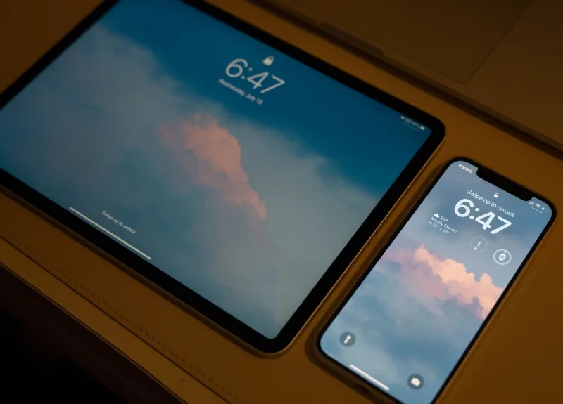 Mano sosteniendo un smartphone mostrando el icono de sincronización en pantalla